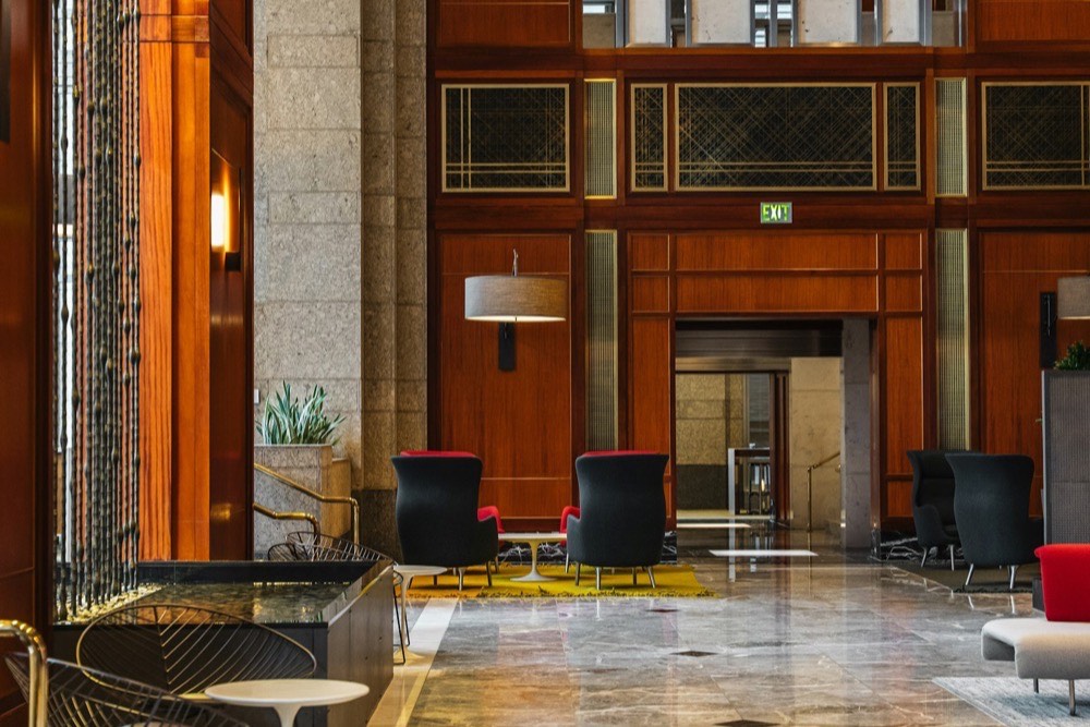 木製パネルとモダンな家具が配された高級ホテルロビーの落ち着いた空間