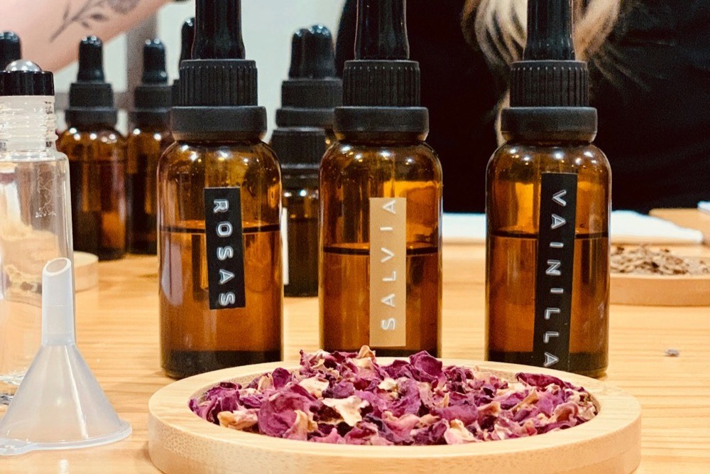 エッセンシャルオイルのボトルとドライフラワーが並ぶ調香作業テーブル